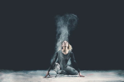 Studio shot of young woman against black background