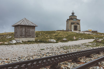 View of railroad tracks by building against sky