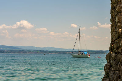 Sailboat sailing on sea against sky