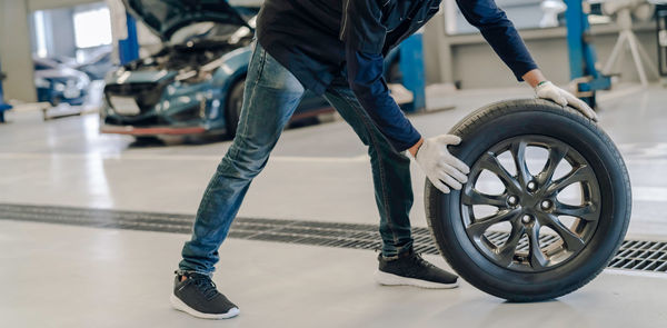 Low section of man with bicycle on road