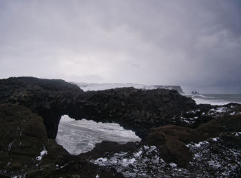 Rock formations on sea shore against sky