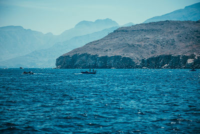 Scenic view of sea and mountains against sky