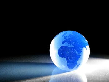 Close-up of blue crystal ball against black background