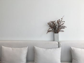 Close-up of cushion on sofa by wall at home