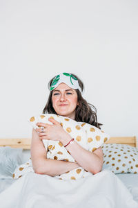 Portrait of a smiling young woman lying on bed at home