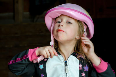 Cute little girl puts on a bike helmet for safety