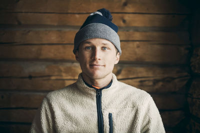 Portrait of young man standing against wall