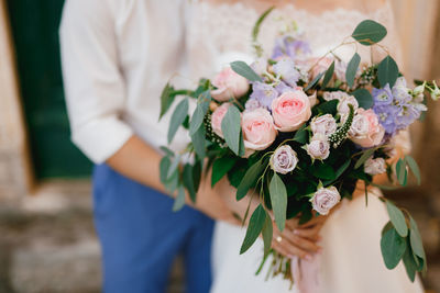 Midsection of woman holding flower bouquet