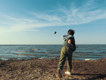 Portrait of boy throwing a rock into the sea