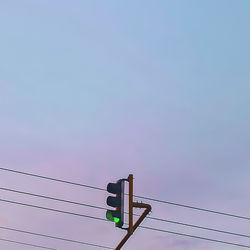 Low angle view of power lines against sky during sunset