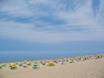 Multi colored umbrellas on beach against sky