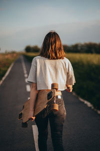 Rear view of woman standing on road