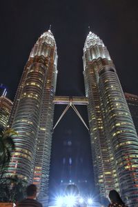 Low angle view of illuminated buildings against sky at night