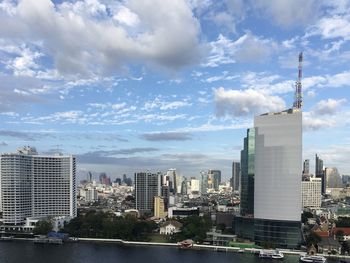 Buildings in city against cloudy sky