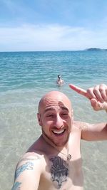 Portrait of smiling man in sea against sky