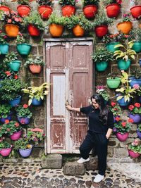 Woman standing by potted plants