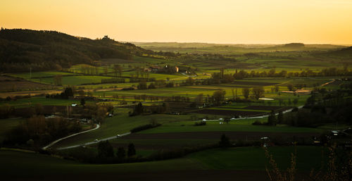 Scenic view of agricultural field against sky during sunset