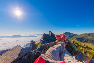 Rear view of man on mountain against blue sky