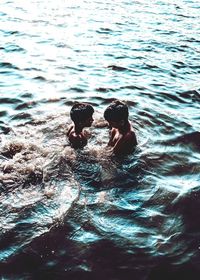 High angle view of people swimming in sea