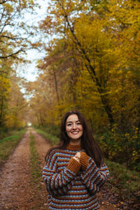 Portrait of young woman standing in forest