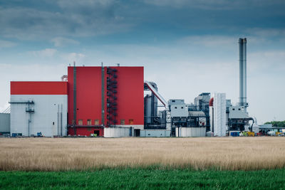 Factory on field against sky