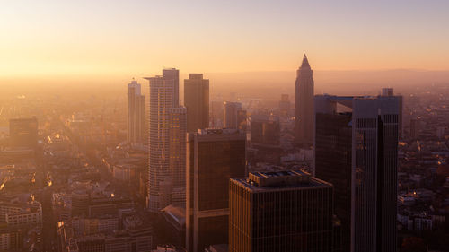 Aerial view of illuminated buildings in city during sunset