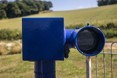 Close-up of coin-operated binoculars on field