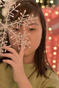 Close-up portrait of a young woman holding plant