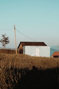 House on field against clear sky