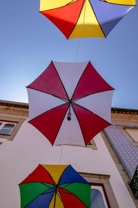 Low angle view of multi colored umbrellas against sky