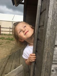 Portrait of girl standing by fence