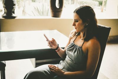 Young woman using smart phone at home