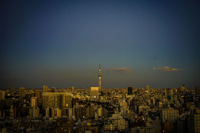 Illuminated cityscape against sky at night