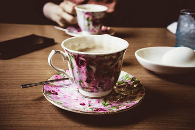 Close-up of hand holding drink served on table