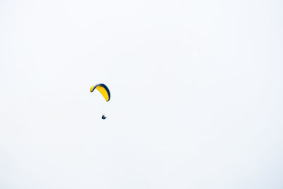 Low angle view of person paragliding against clear sky