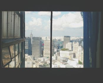 Cityscape against sky seen through window