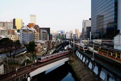 Bridge over river in city against clear sky