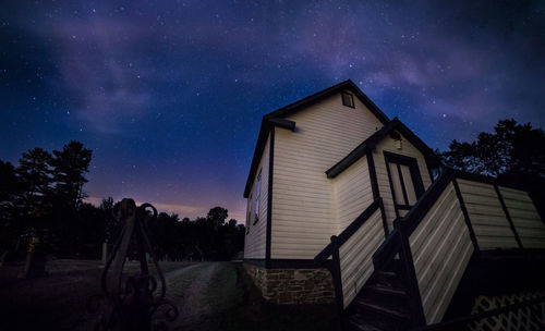 Low angle view of cottage against sky at night