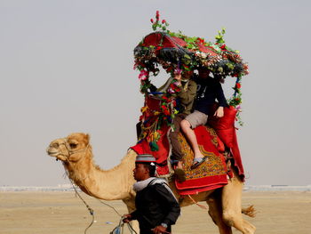 Men standing on desert against clear sky