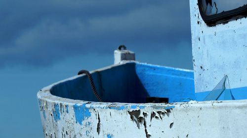 Close-up of ship moored against blue sky