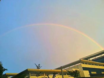 Low angle view of rainbow over built structure