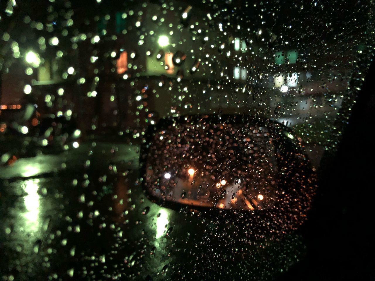 CLOSE-UP OF WATER DROPS ON ILLUMINATED GLASS