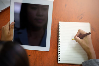 Midsection of person reading book on table