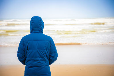 Rear view of man standing on beach