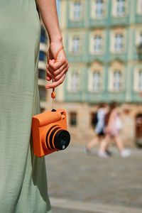 Female tourist captures memories during travel with vintage instant camera