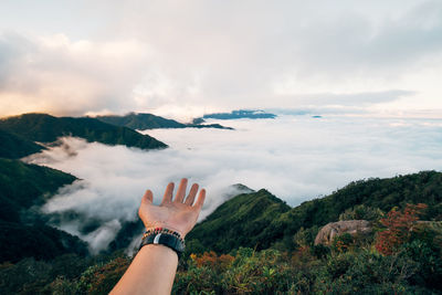 Midsection of person on mountain against sky