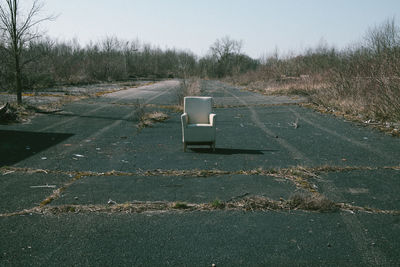 Armchair on road against clear sky