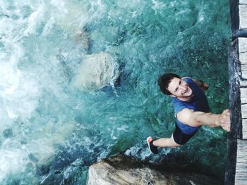 High angle view of man hanging on one arm