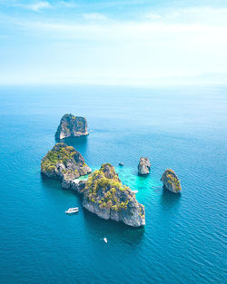 Aerial view of tiny islands against blue sea and sky