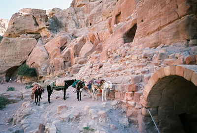 Tourists on rock formation against sky